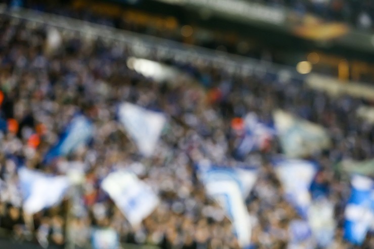 Blurred Football Fans Waving Flags